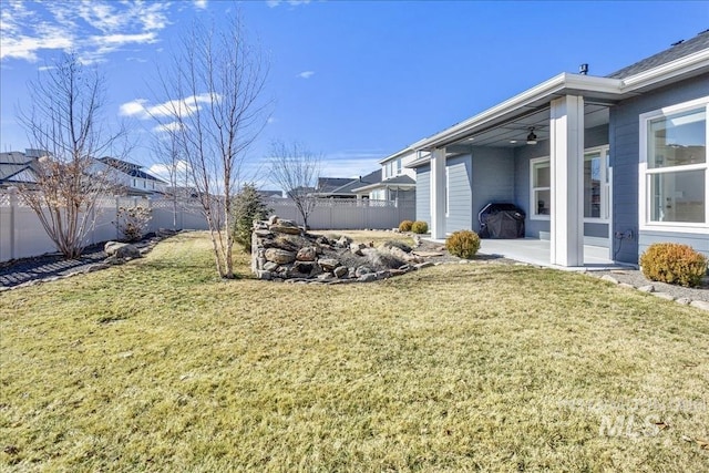 view of yard featuring a ceiling fan, a fenced backyard, and a patio