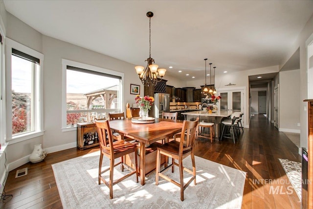 dining space featuring a notable chandelier and dark wood-type flooring