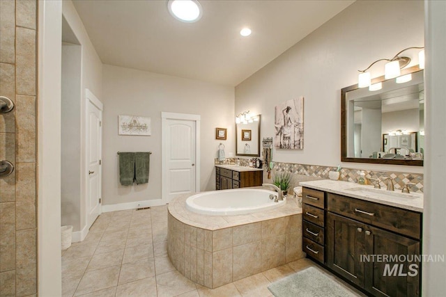 bathroom featuring vanity, tiled bath, and tile patterned flooring