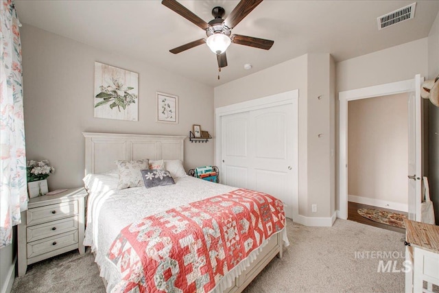 carpeted bedroom featuring a closet and ceiling fan