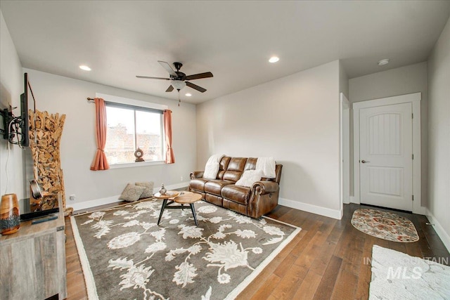 living room with ceiling fan and dark hardwood / wood-style floors