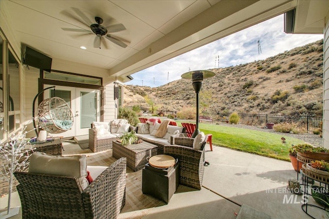 view of patio featuring outdoor lounge area, a mountain view, french doors, and ceiling fan