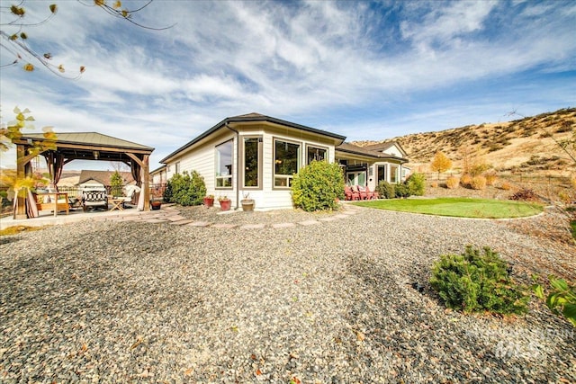 back of property with a gazebo and a patio area