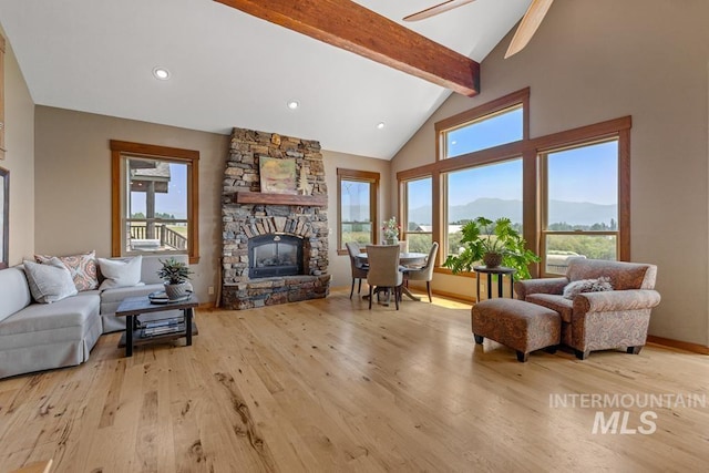 41 Knob Hill Dr, Mccall, ID 83638 - living area featuring wood finished floors, healthy amount of natural light, beamed ceiling, a stone fireplace, and ceiling fan