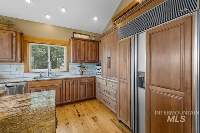 41 Knob Hill Dr, Mccall, ID 83638 - kitchen featuring paneled fridge, dishwasher, a sink, brown cabinets, and vaulted ceiling