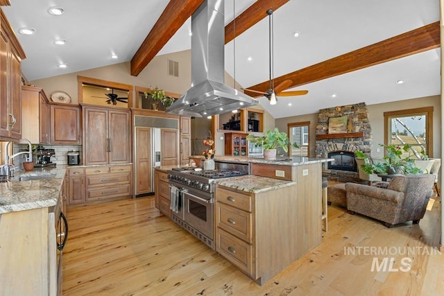 41 Knob Hill Dr, Mccall, ID 83638 - kitchen with a ceiling fan, high end appliances, island range hood, a sink, and a stone fireplace