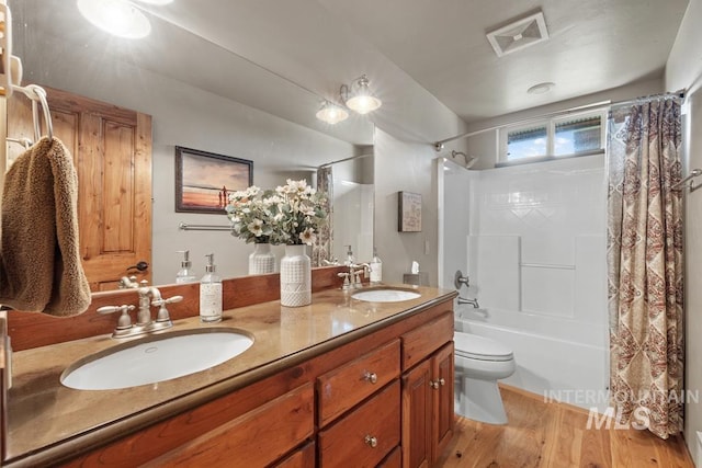 41 Knob Hill Dr, Mccall, ID 83638 - bathroom with double vanity, wood finished floors, toilet, and shower / tub combo with curtain