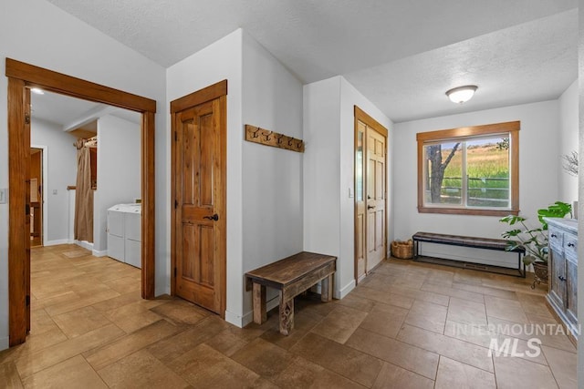 41 Knob Hill Dr, Mccall, ID 83638 - foyer entrance with washing machine and dryer, baseboards, a textured ceiling, and stone finish floors