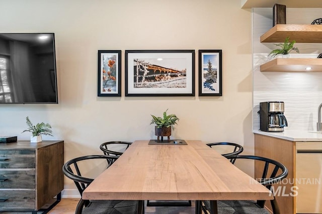 dining space with baseboards and wood finished floors