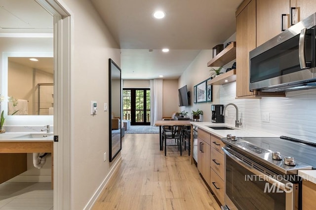 kitchen featuring decorative backsplash, modern cabinets, stainless steel appliances, open shelves, and a sink