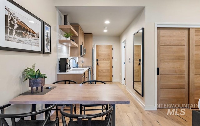 dining room with baseboards, recessed lighting, and light wood-style floors