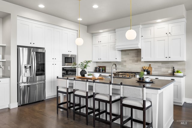 6799 E Warm Springs Ave, Boise, ID 83716 - kitchen featuring appliances with stainless steel finishes, dark countertops, a sink, dark wood-style flooring, and tasteful backsplash