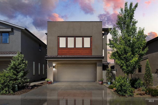 6799 E Warm Springs Ave, Boise, ID 83716 - contemporary home with a standing seam roof, metal roof, a garage, driveway, and stucco siding