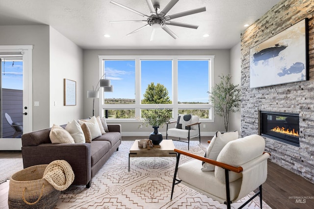 6799 E Warm Springs Ave, Boise, ID 83716 - living area with hardwood / wood-style floors, a ceiling fan, a stone fireplace, healthy amount of natural light, and recessed lighting