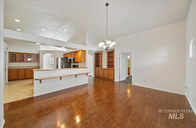 431 N David Frost St, Nampa, ID 83651 - kitchen featuring appliances with stainless steel finishes, brown cabinetry, a chandelier, a breakfast bar, and arched walkways
