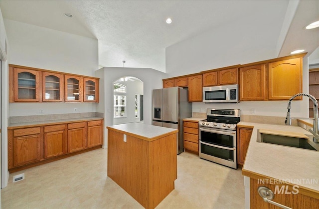 431 N David Frost St, Nampa, ID 83651 - kitchen with stainless steel appliances, a sink, arched walkways, light countertops, and brown cabinets