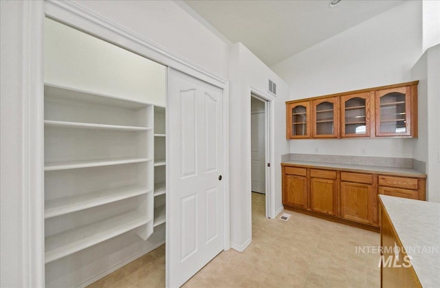 431 N David Frost St, Nampa, ID 83651 - kitchen featuring brown cabinets, light countertops, glass insert cabinets, light floors, and baseboards
