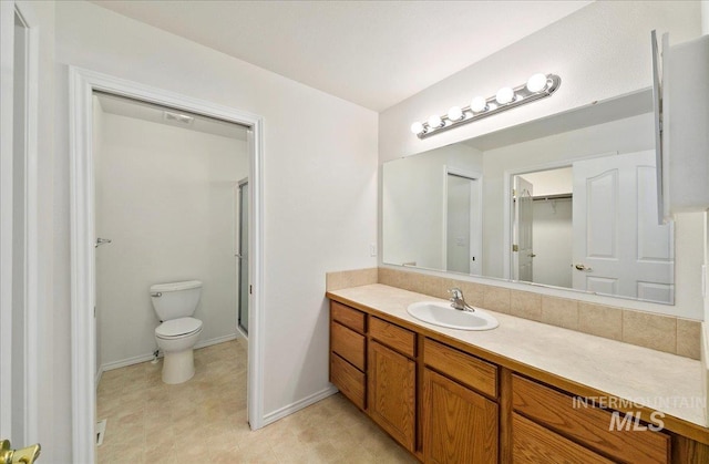 431 N David Frost St, Nampa, ID 83651 - bathroom featuring toilet, vanity, a shower with door, baseboards, and a walk in closet