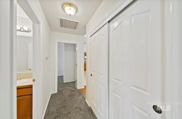 431 N David Frost St, Nampa, ID 83651 - hall with baseboards, dark colored carpet, and a sink