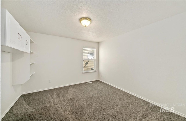 431 N David Frost St, Nampa, ID 83651 - empty room with dark carpet, baseboards, and a textured ceiling