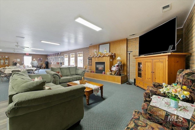 431 N David Frost St, Nampa, ID 83651 - living area featuring wooden walls, carpet floors, plenty of natural light, ceiling fan, and brick wall