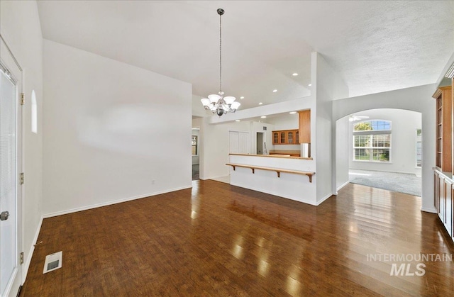 431 N David Frost St, Nampa, ID 83651 - unfurnished living room featuring arched walkways, dark wood-style flooring, a chandelier, baseboards, and recessed lighting