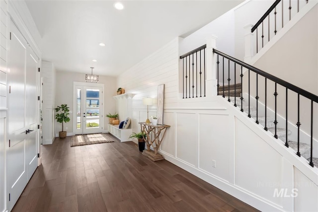 foyer with dark hardwood / wood-style flooring and a chandelier