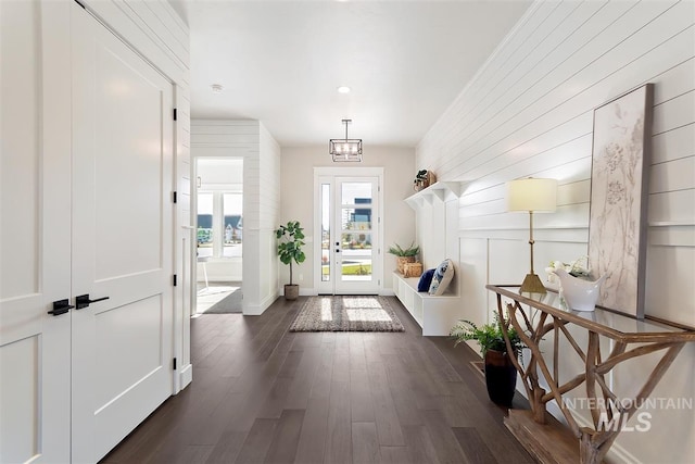 entryway with an inviting chandelier and dark wood-type flooring