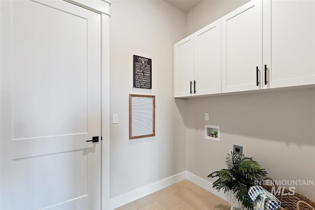 clothes washing area with hookup for an electric dryer, light hardwood / wood-style flooring, washer hookup, and cabinets