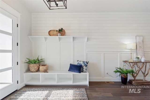 mudroom featuring wood walls, a healthy amount of sunlight, and dark hardwood / wood-style flooring