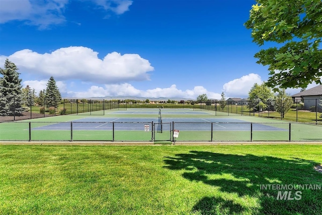 view of tennis court featuring a yard