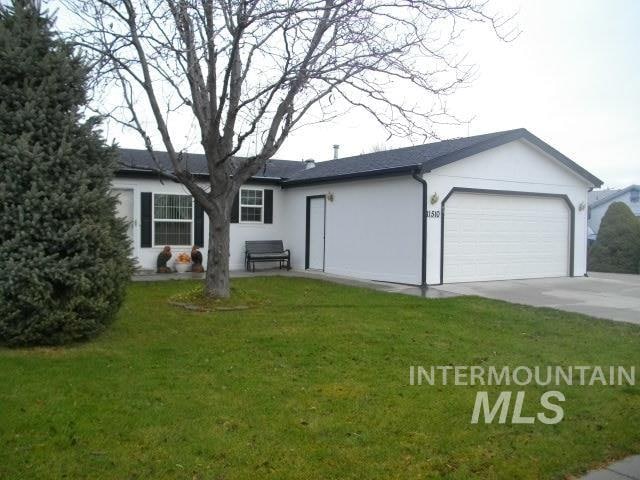 ranch-style house featuring stucco siding, an attached garage, concrete driveway, and a front yard