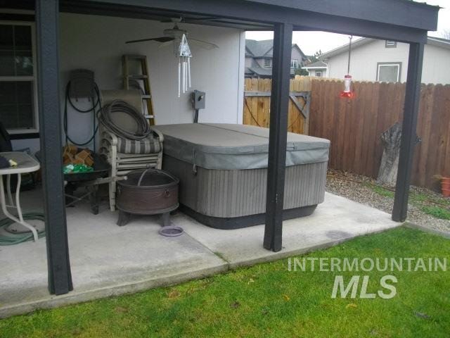 view of patio / terrace with fence and a hot tub