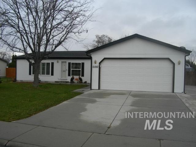 single story home with a front lawn, a garage, driveway, and stucco siding