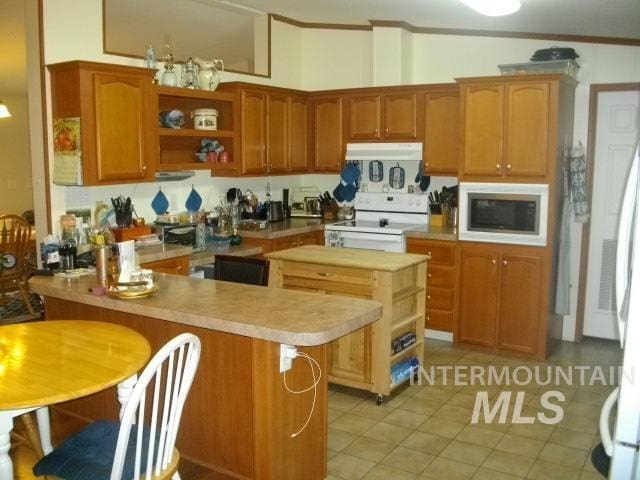 kitchen with built in microwave, electric range, a peninsula, and open shelves