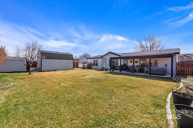 view of yard with a patio, an outbuilding, a shed, a fenced backyard, and a hot tub