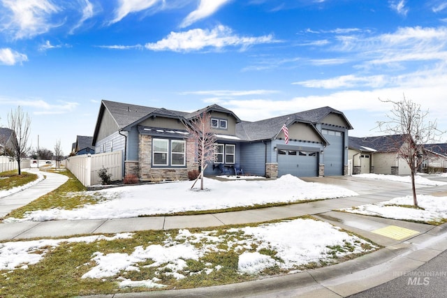 view of front of home featuring stone siding, an attached garage, and driveway