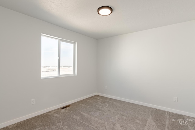 unfurnished room with visible vents, carpet floors, and baseboards