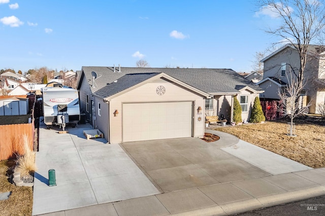 view of front of property featuring a residential view, concrete driveway, and fence