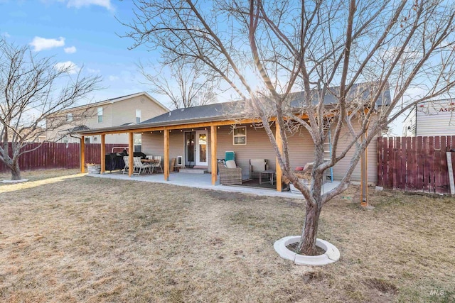 rear view of house featuring a yard, a fenced backyard, and a patio