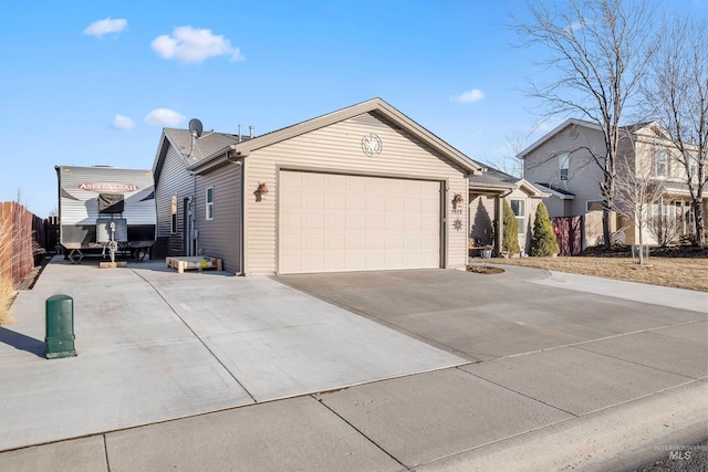 view of home's exterior with a garage, concrete driveway, and fence