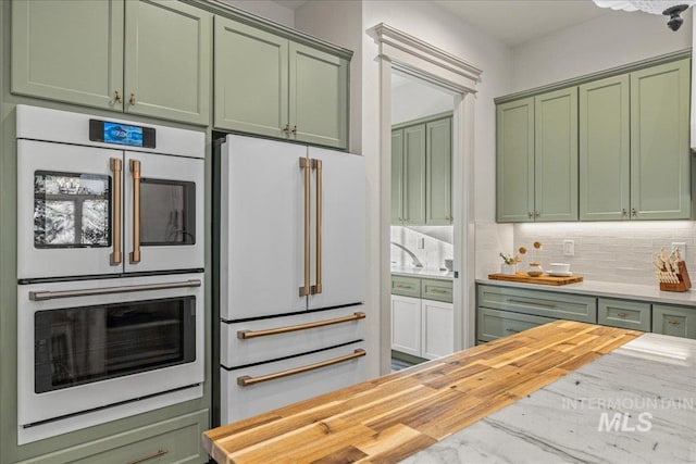 25580 Gooseberry Ln, Caldwell, ID 83607 - kitchen with green cabinets, white appliances, butcher block countertops, and backsplash