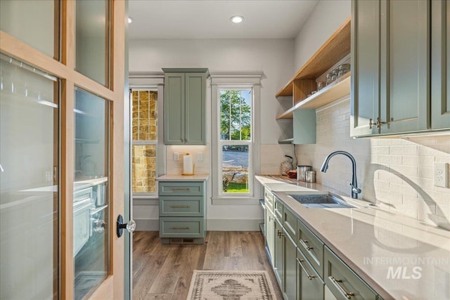 25580 Gooseberry Ln, Caldwell, ID 83607 - kitchen with green cabinets, a sink, open shelves, light wood finished floors, and tasteful backsplash