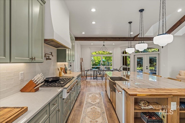 25580 Gooseberry Ln, Caldwell, ID 83607 - kitchen with premium range hood, french doors, light wood finished floors, stainless steel gas stovetop, and white dishwasher