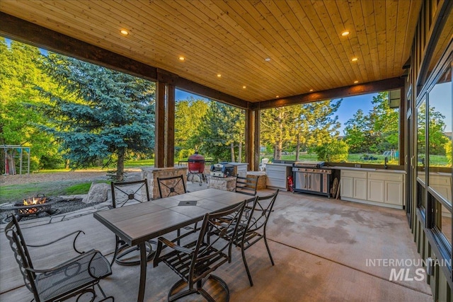 25580 Gooseberry Ln, Caldwell, ID 83607 - view of patio with a fire pit, outdoor dining space, a sink, and view of scattered trees