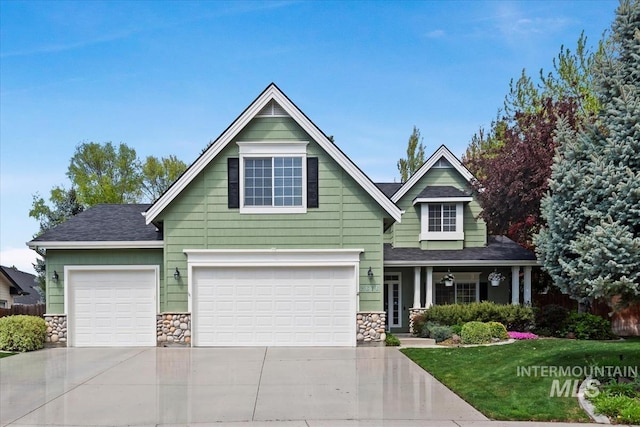 craftsman-style home with roof with shingles, a front lawn, stone siding, a garage, and driveway