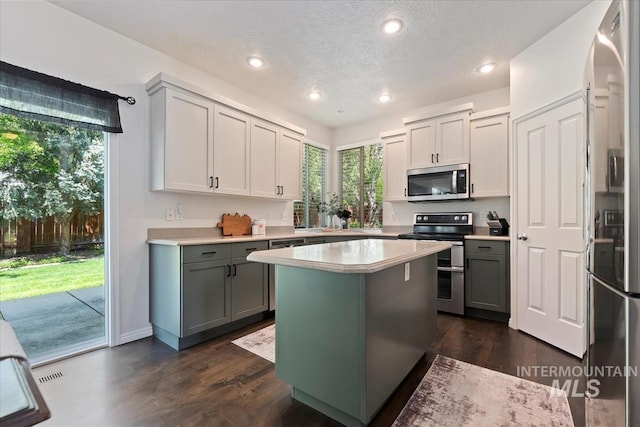 kitchen featuring light countertops, appliances with stainless steel finishes, plenty of natural light, and gray cabinets