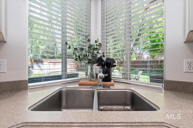 details with light countertops and a textured wall