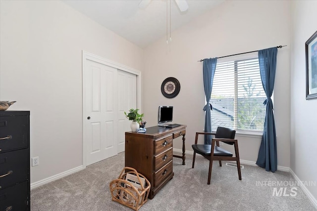 office area featuring a ceiling fan, baseboards, and light carpet