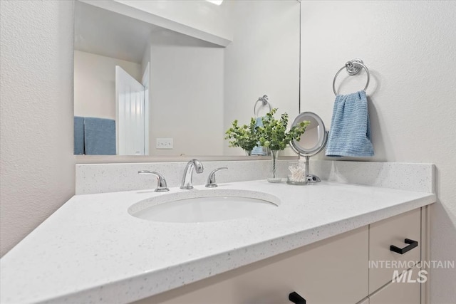 bathroom featuring vanity and a textured wall